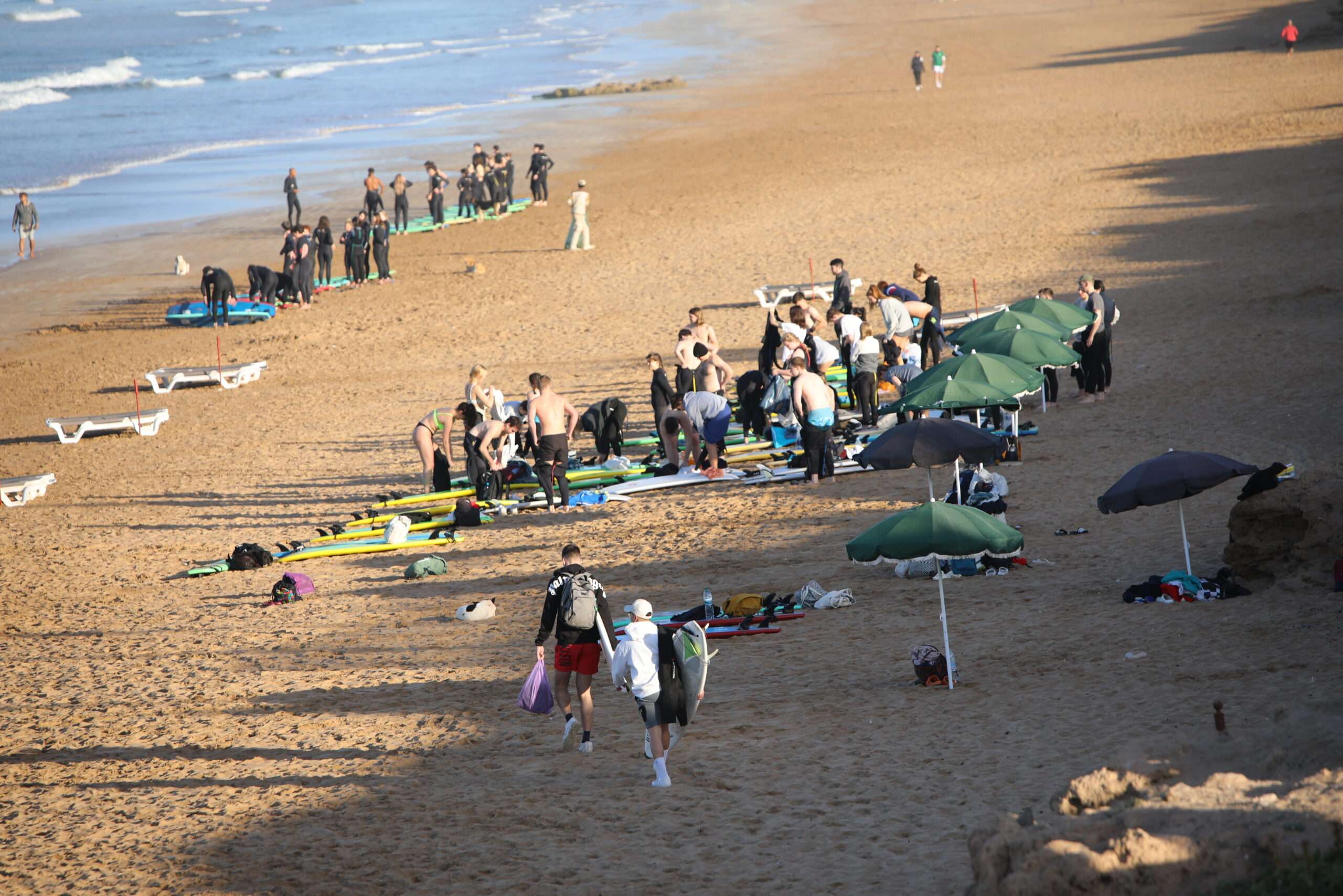 "A group of surfers waiting for the wave, ready to take on the ocean."