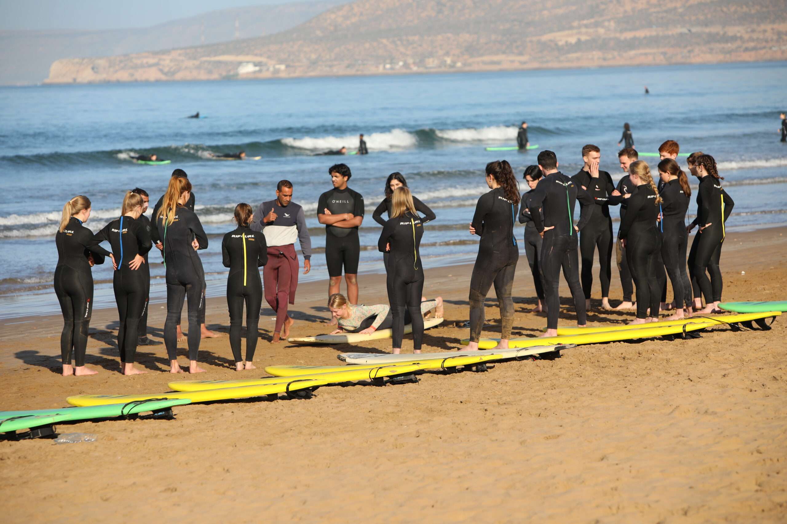 "A group of surfers waiting for the wave, ready to take on the ocean."