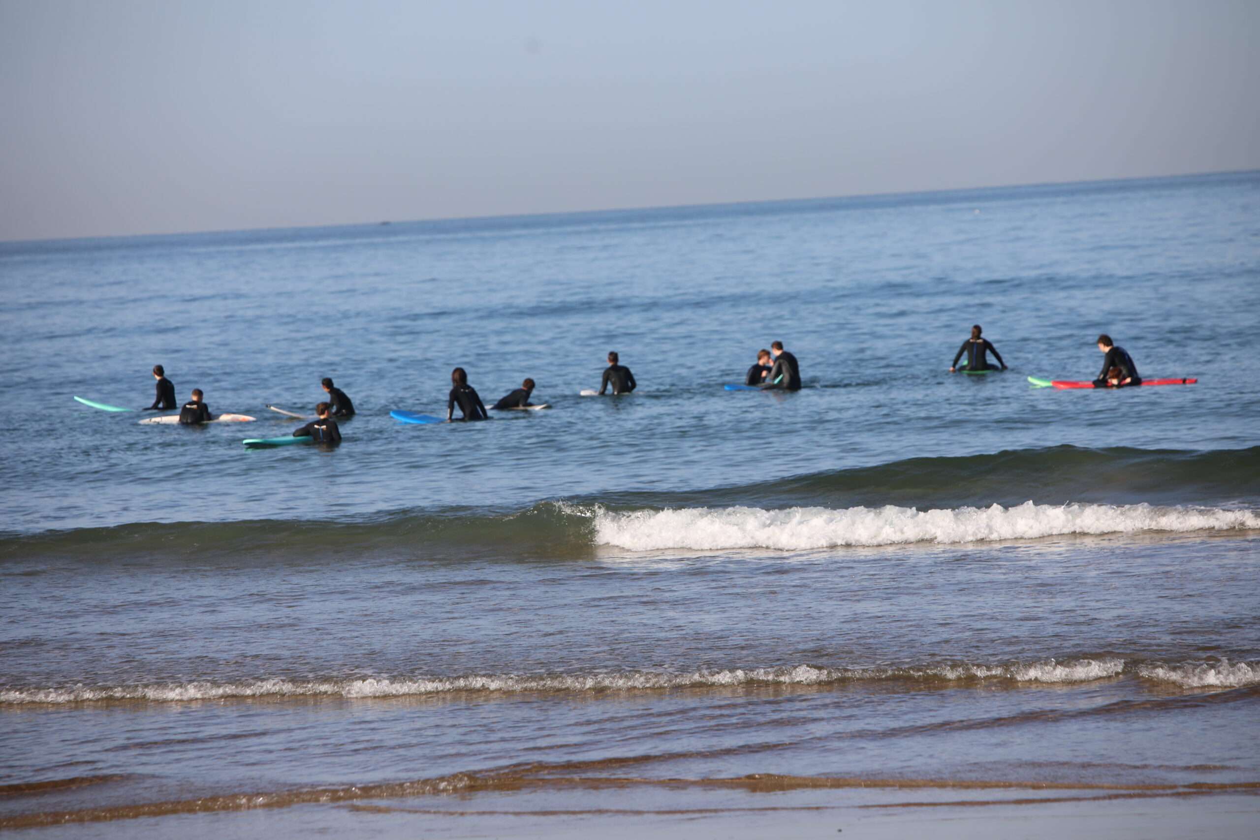 "A group of surfers waiting for the wave, ready to take on the ocean."