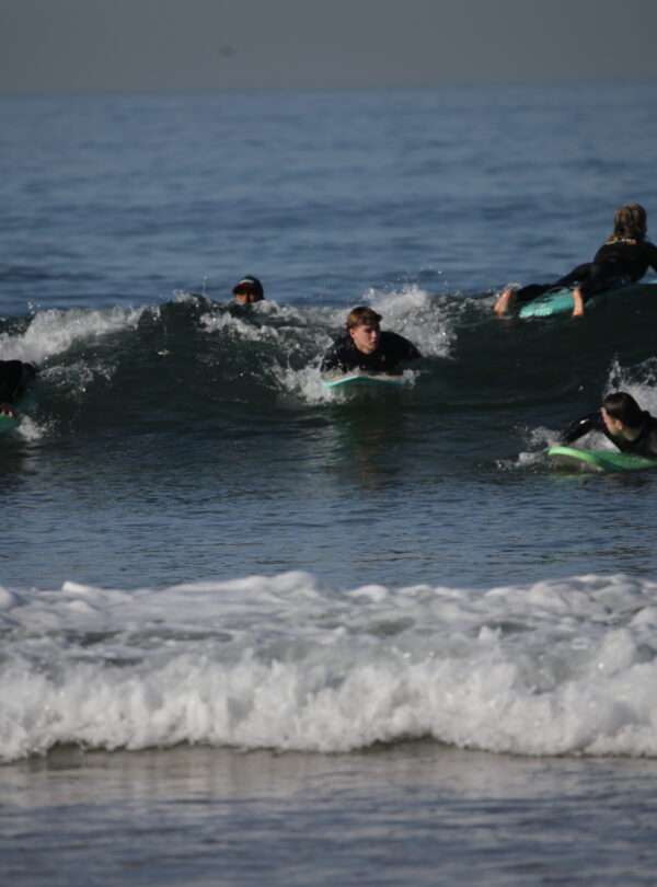 "Three boys surfing on waves."