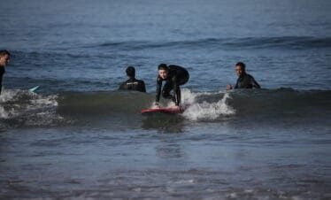 "A girl surfing on a wave."