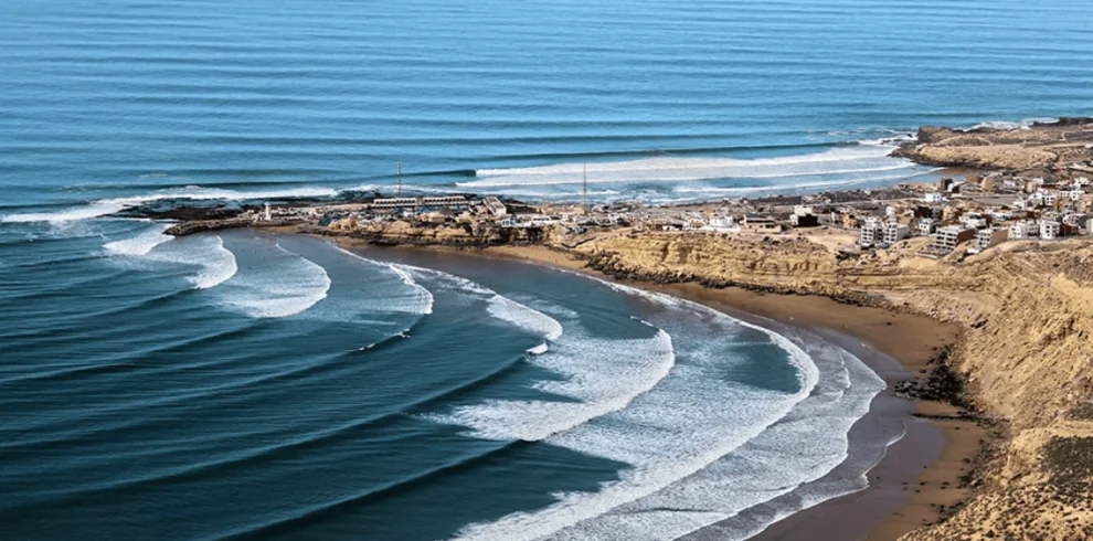 "Spectacular landscape of Imsouane with its beach, waves, and majestic mountains in the background."