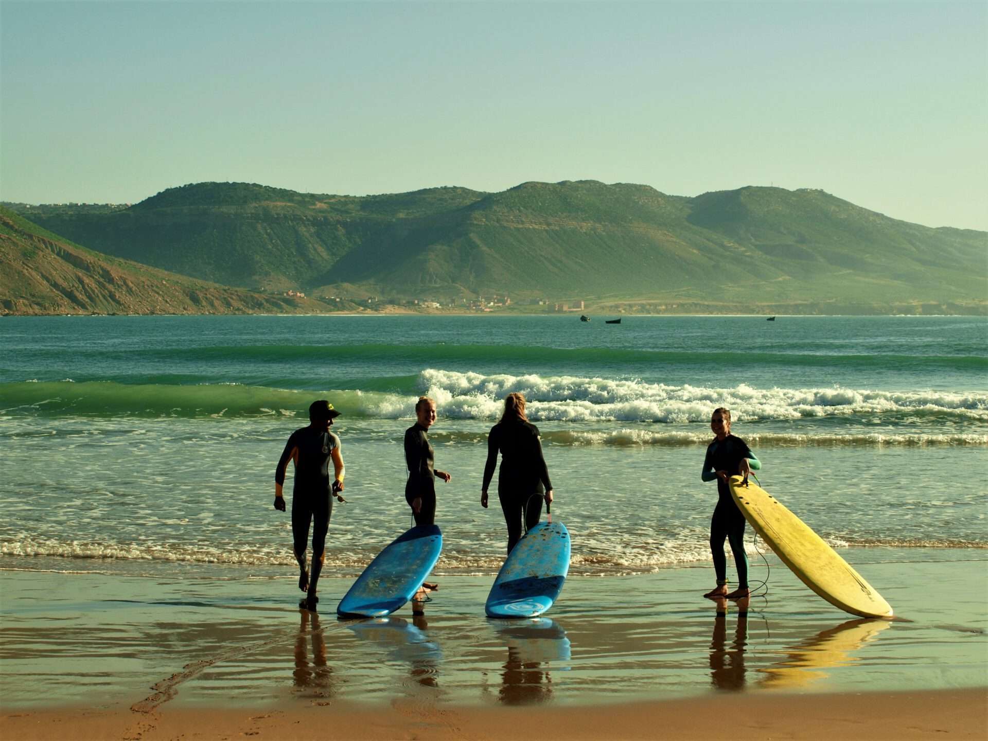 "Guys carrying their surfboards towards the sea, ready to catch the waves."