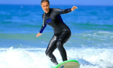 "A girl surfing on a wave."